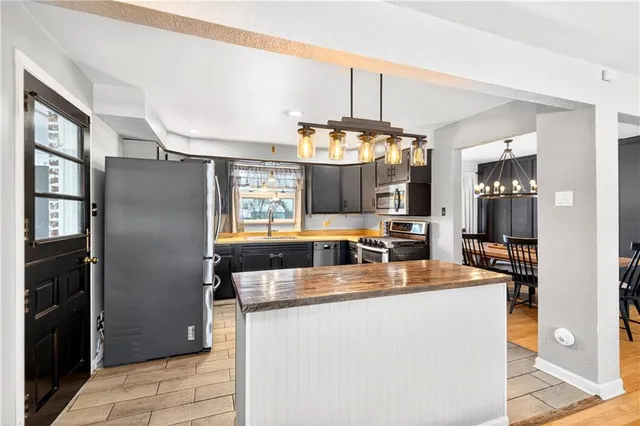 a kitchen with a refrigerator and chandelier