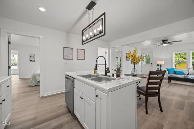 a view of kitchen island with stainless steel appliances refrigerator stove and wooden floor