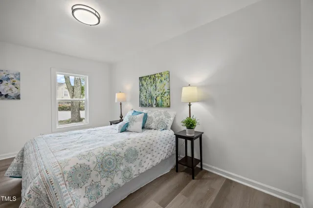 a bedroom with a bed table and a window