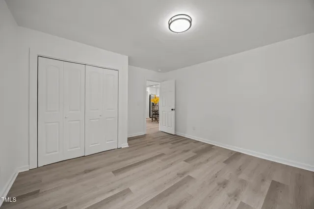 an empty room with wooden floor and window
