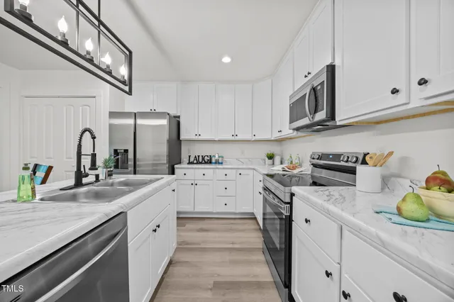 a kitchen with white cabinets and appliances