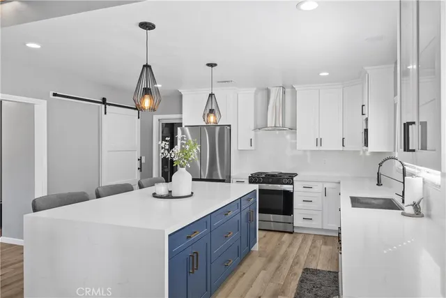 a kitchen with kitchen island granite countertop a sink stove and refrigerator