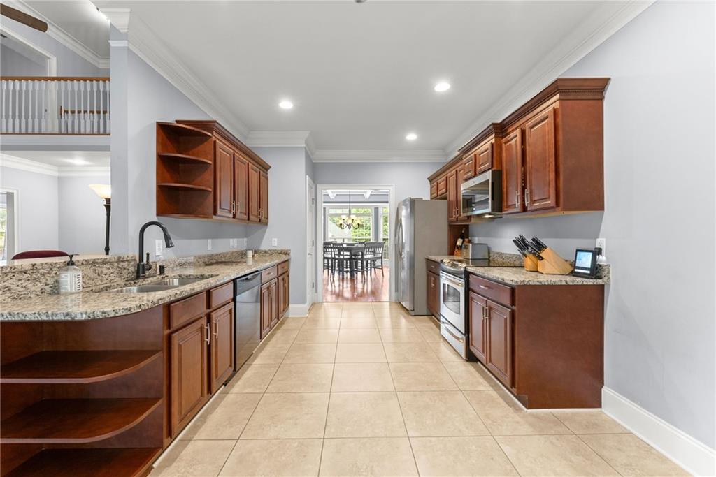 6643 Windvane Point Clermont, GA 30527 - Photo 18 of 88 a large kitchen with stainless steel appliances granite countertop a stove a sink and a refrigerator