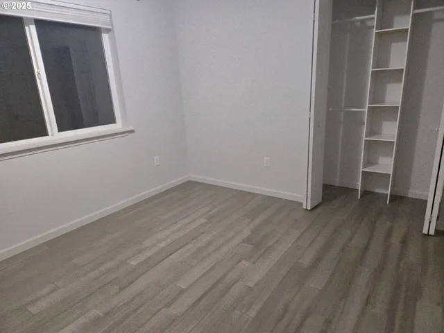 an empty room with wooden floor and closet