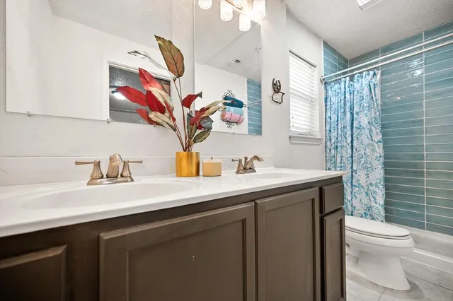 a bathroom with a sink vanity mirror and toilet
