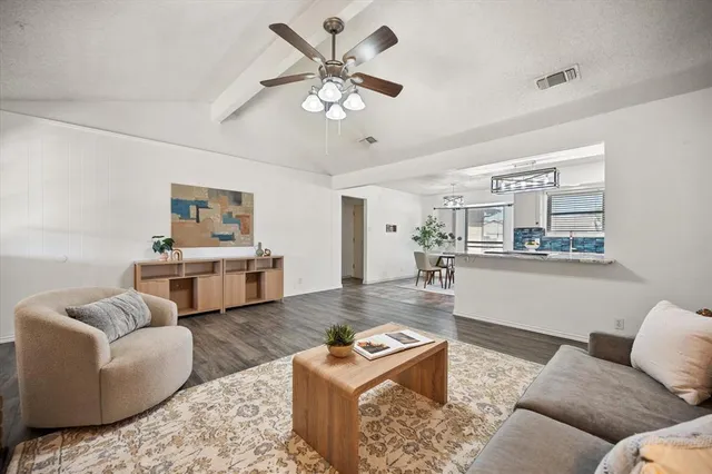 a living room with furniture and view of kitchen