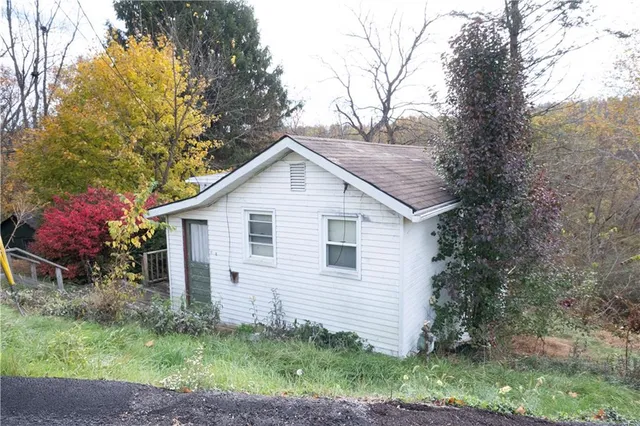 a view of house with a yard and potted plants