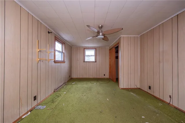 a view of a livingroom with a ceiling fan & entryway