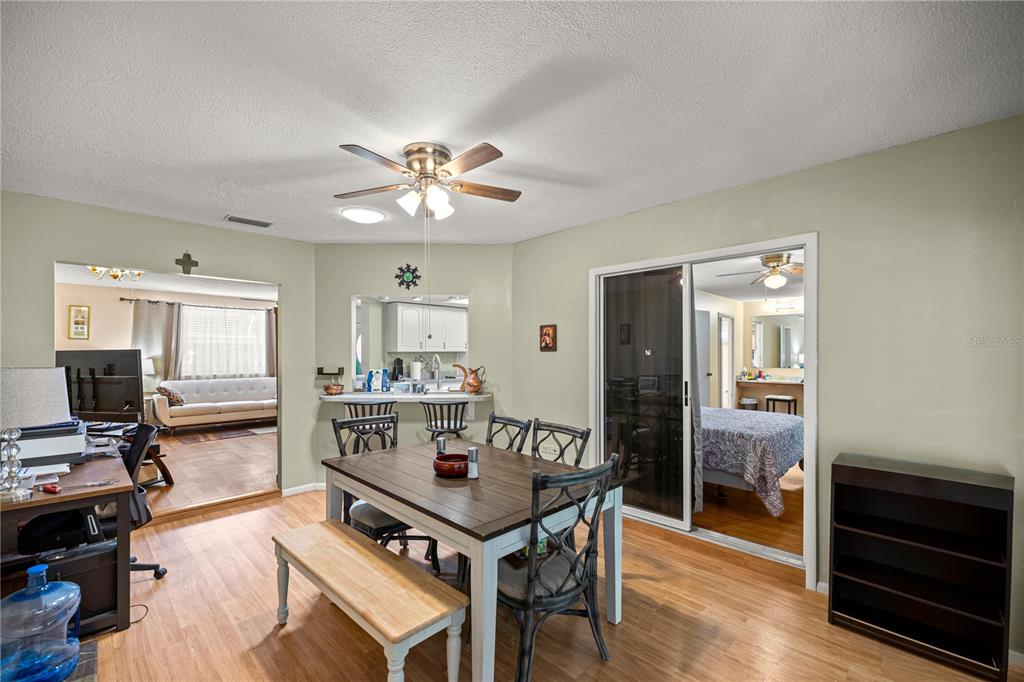 9021 Southwest 108th Place Ocala, FL 34481 - Photo 12 of 30 a living room with a table chairs a flat screen tv and a refrigerator