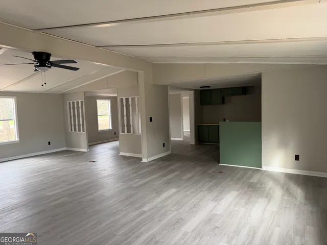 a view of a livingroom with wooden floor and a ceiling fan