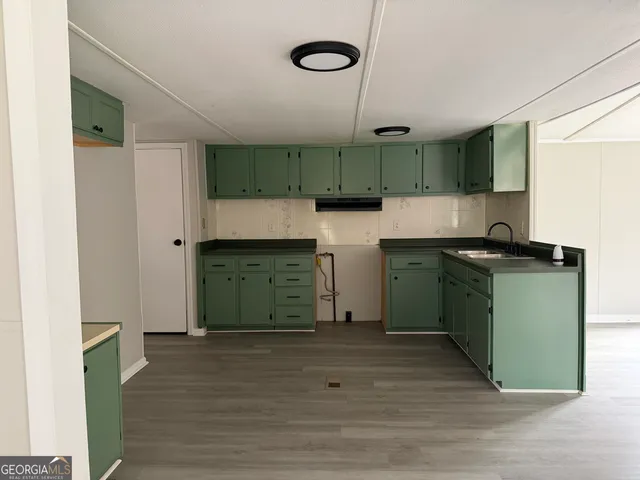 a kitchen with a sink cabinets and wooden floor