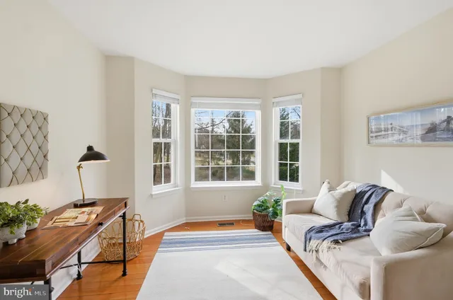 a living room with furniture and two window