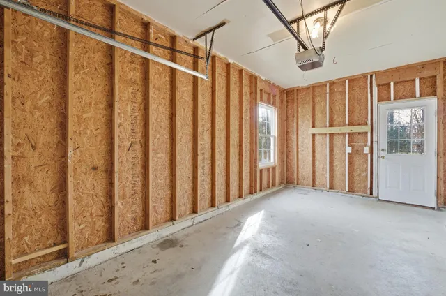 a living room with couches and kitchen view with wooden floor