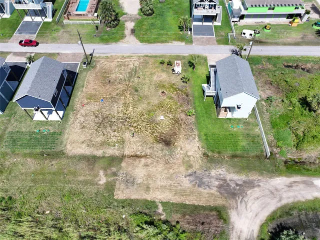 an aerial view of a house with a yard and lake view