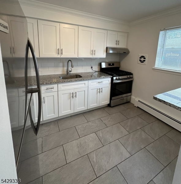 1173 Valley Road Wayne, NJ 07470 - Photo 4 of 11 a kitchen with a sink a stove and cabinets