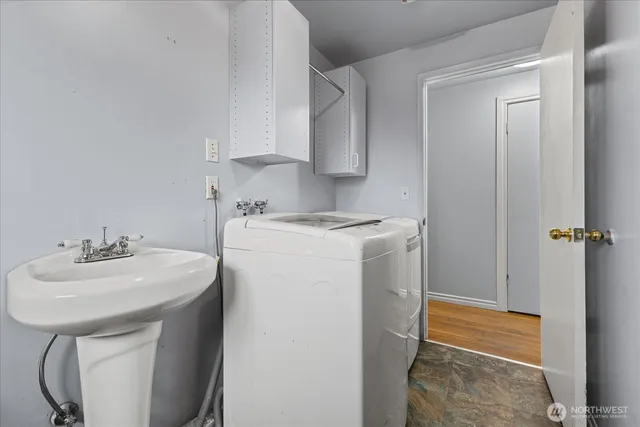 a utility room with sink dryer and washer