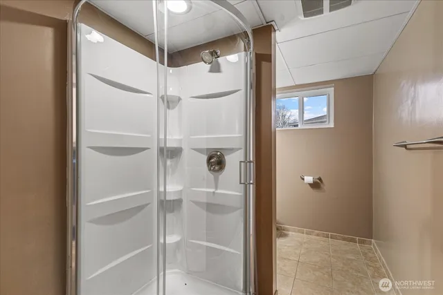 a bathroom with a glass door shower and a sink
