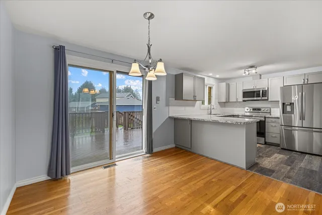 a kitchen with stainless steel appliances kitchen island granite countertop a refrigerator a stove top oven a sink and dishwasher