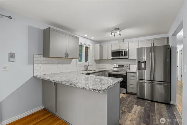 a kitchen with kitchen island granite countertop a sink appliances cabinets and counter space