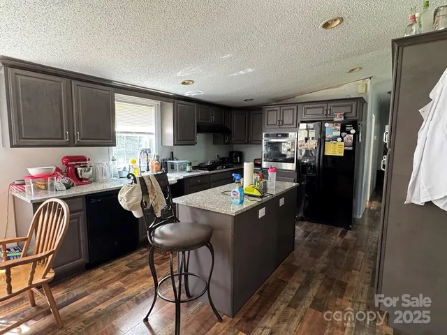 a living room with stainless steel appliances kitchen island granite countertop furniture a dining table and chairs