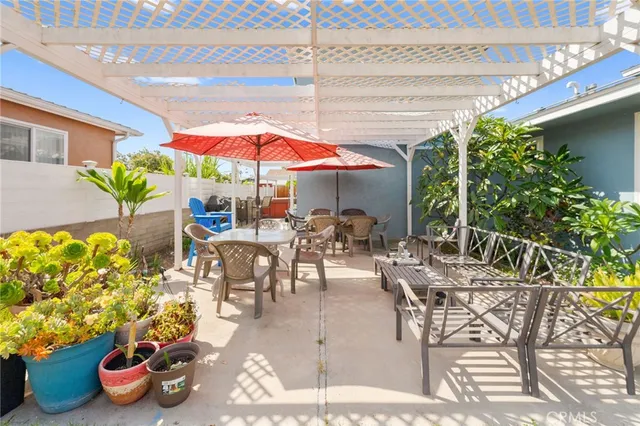 a view of a patio with dining table and chairs under an umbrella