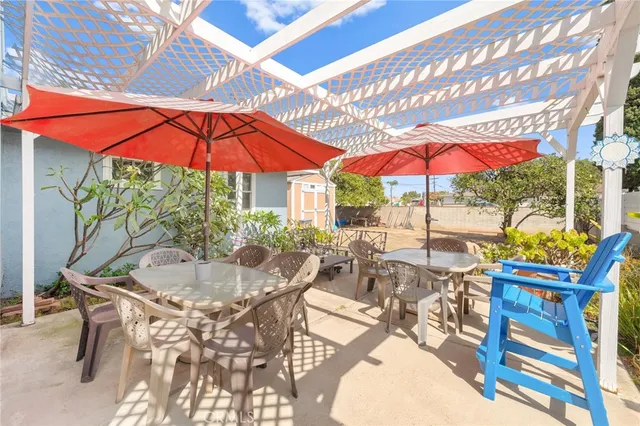 a view of patio with chairs and table under an umbrella
