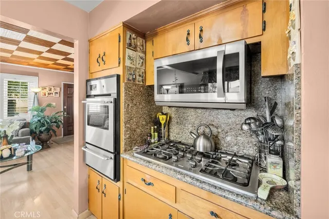 a kitchen with stainless steel appliances granite countertop a stove and a shower