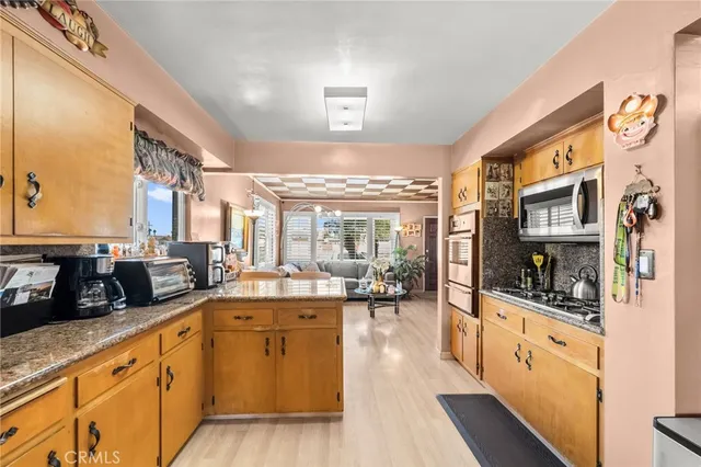 a large kitchen with stainless steel appliances double vanity sink and cabinets