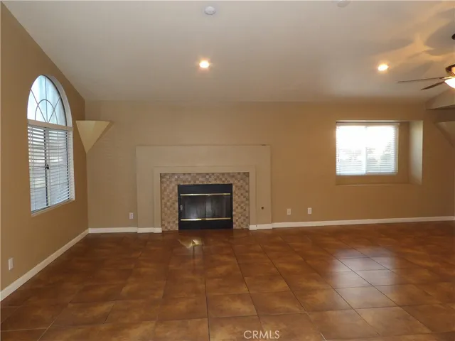 an empty room with windows and fireplace