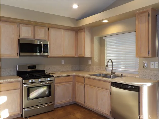a kitchen with sink a microwave a stove and cabinets