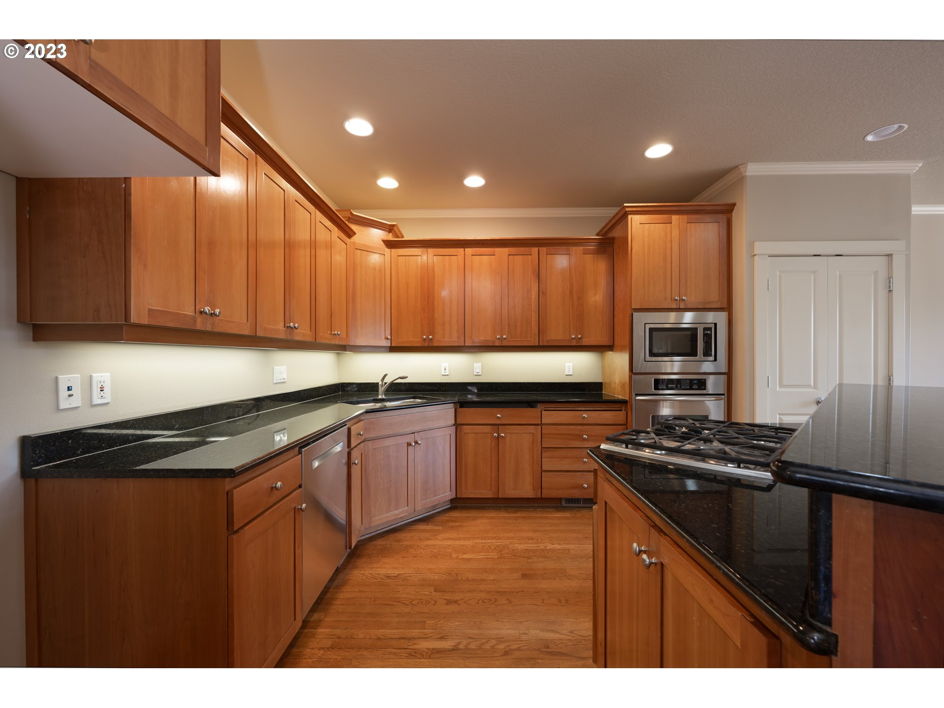 2213 St Moritz Loop West Linn, OR 97068 - Photo 22 of 48 a kitchen with granite countertop stainless steel appliances and wooden cabinets