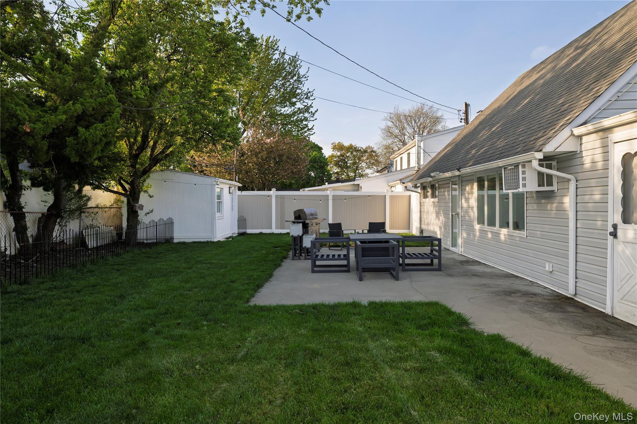 10 Rural Lane Levittown, NY 11756 - Photo 19 of 22 a view of backyard of house with outdoor seating and green space