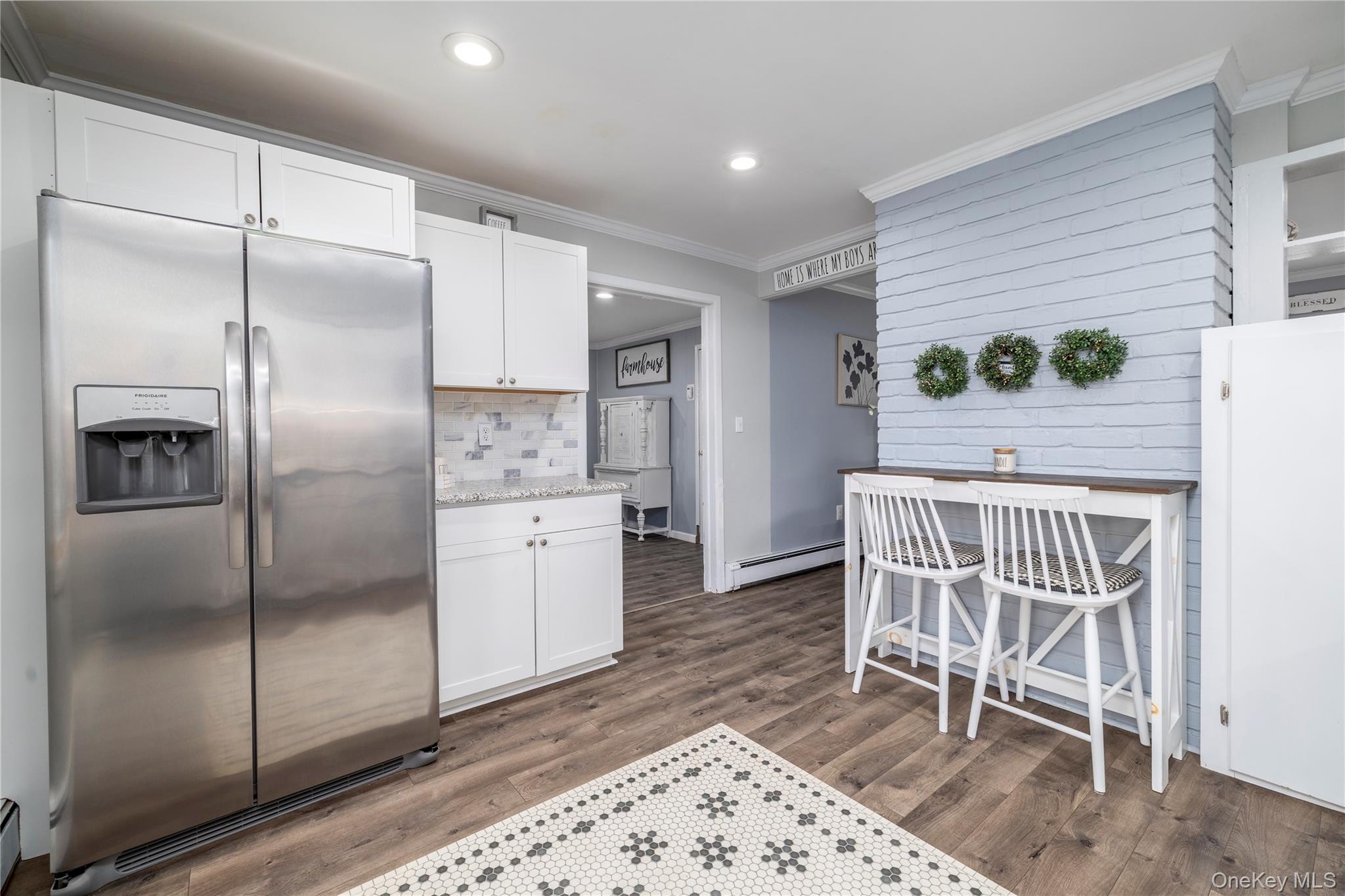 10 Rural Lane Levittown, NY 11756 - Photo 9 of 22 a kitchen with a refrigerator a table and chairs
