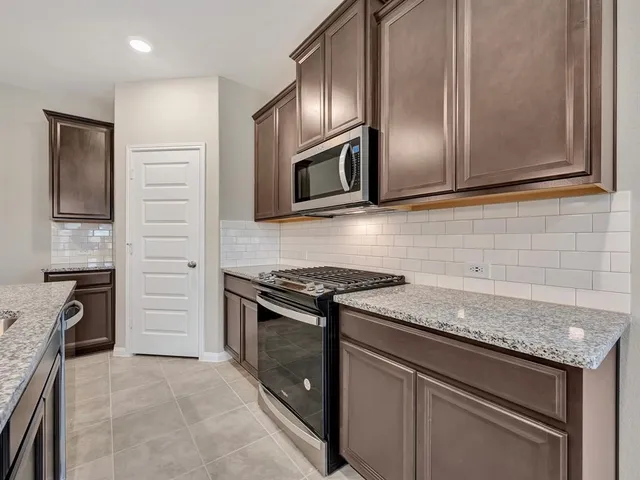 a kitchen with granite countertop stainless steel appliances and cabinets