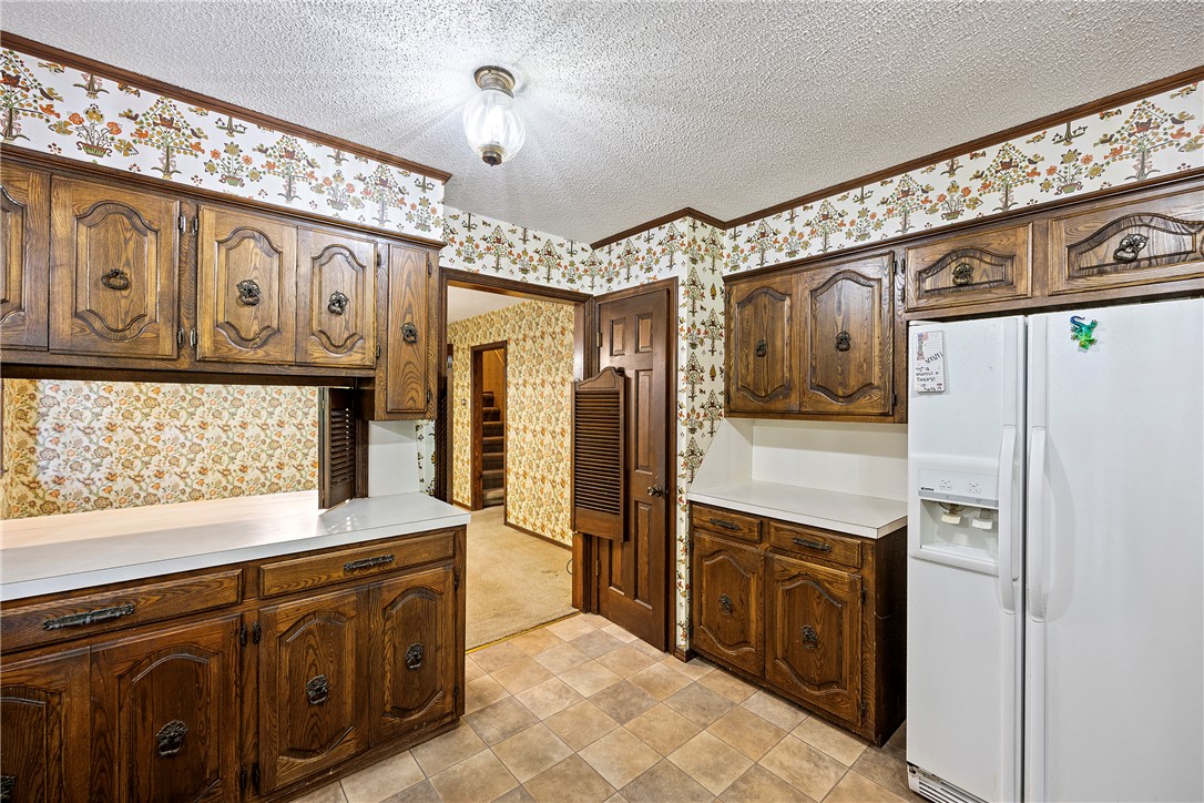 411 Marina Road Russellville, AR 72802 - Photo 12 of 49 Kitchen featuring wood cabinetry with decorative hardware, white countertops, and tiled flooring