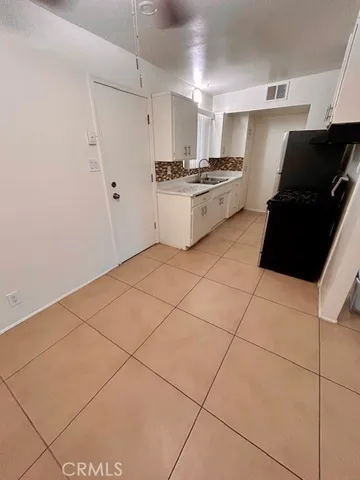 a kitchen with granite countertop a stove a sink and a refrigerator