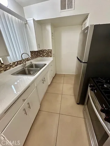 a kitchen with a sink appliances and cabinets