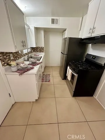 a kitchen with a sink a stove and a refrigerator
