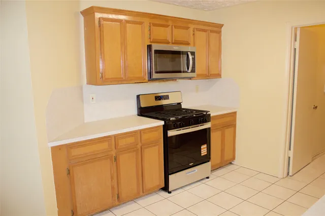 a kitchen with granite countertop white cabinets and stainless steel appliances