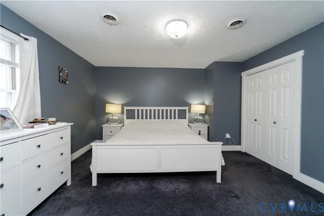 a spacious bedroom with a bed and a dresser