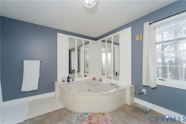 a spacious bathroom with a tub and a large window