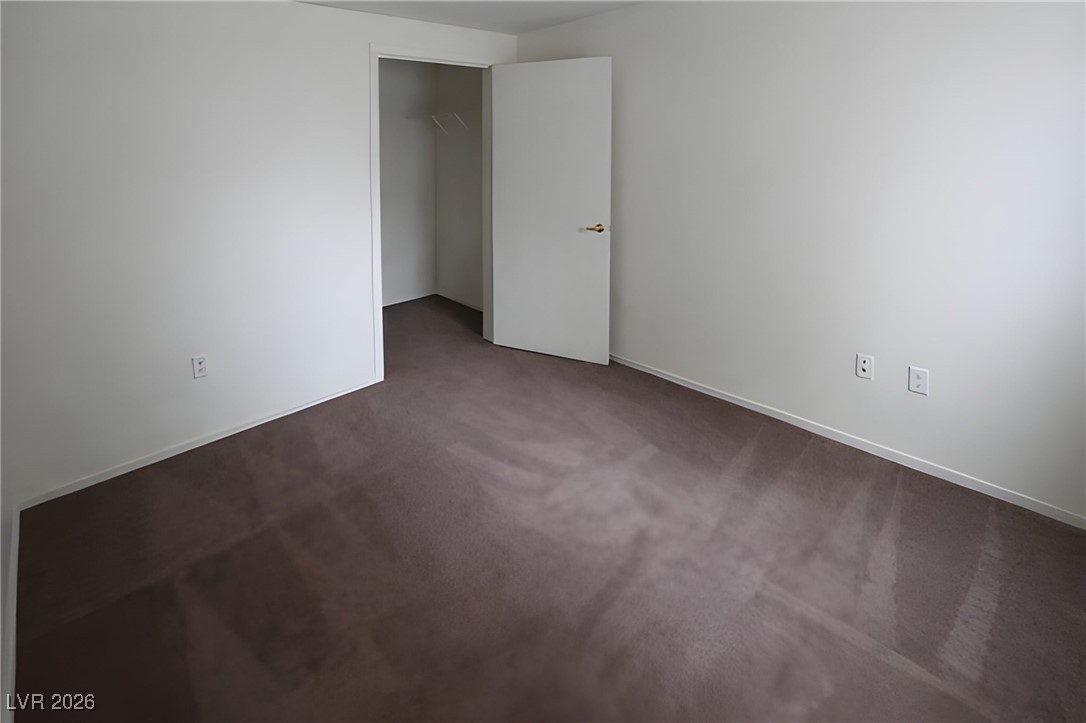 6650 West Warm Springs Road, Unit 1064 Las Vegas, NV 89118 - Photo 8 of 10 Empty room with dark carpet and baseboards