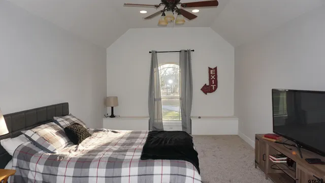 a bedroom with a bed and a flat screen tv