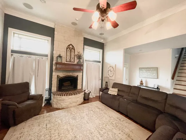 a living room with furniture a fireplace and a chandelier
