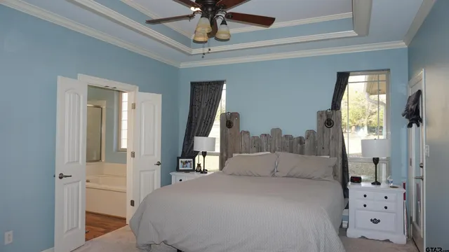 a spacious bedroom with a bed and a chandelier