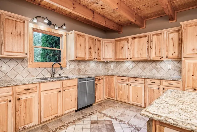 a kitchen with stainless steel appliances granite countertop a stove a sink and a refrigerator with wooden cabinets