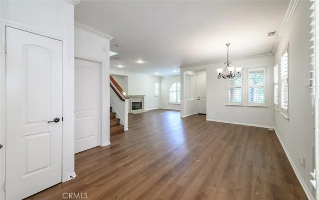a view of a livingroom with wooden floor and stairs