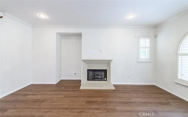 a view of empty room with wooden floor and fireplace