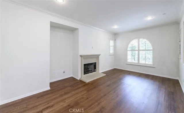 a view of empty room with wooden floor and window