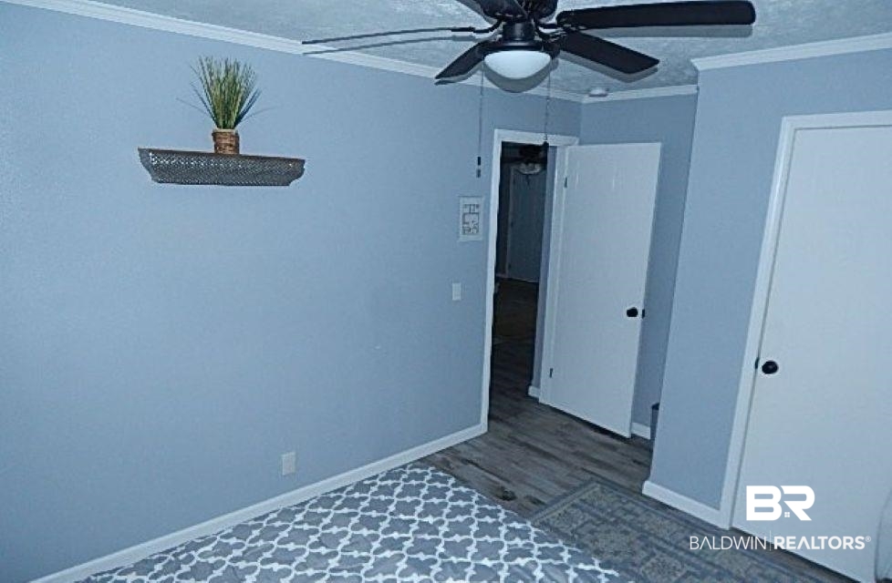 6996 Pinehill Road Daphne, AL 36526 - Photo 13 of 18 Unfurnished bedroom with ornamental molding, wood finished floors, and a ceiling fan